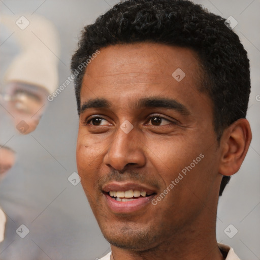 Joyful black young-adult male with short  black hair and brown eyes