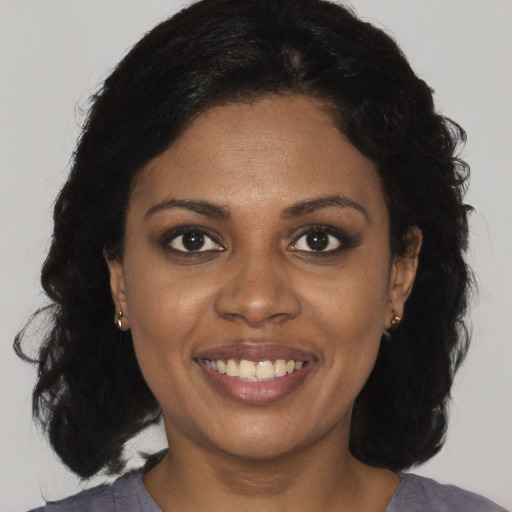Joyful black young-adult female with medium  brown hair and brown eyes
