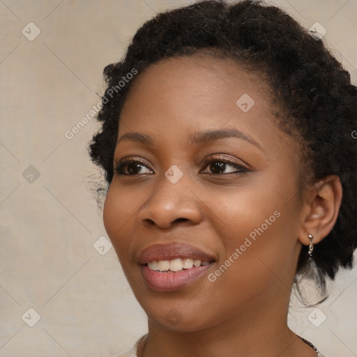 Joyful black young-adult female with long  brown hair and brown eyes