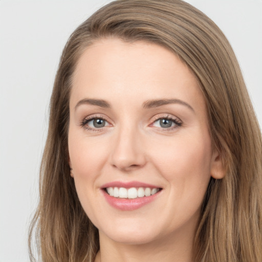 Joyful white young-adult female with long  brown hair and grey eyes