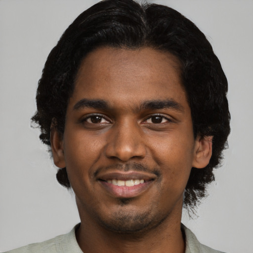 Joyful black young-adult male with short  black hair and brown eyes