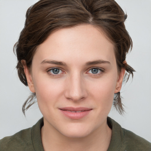 Joyful white young-adult female with medium  brown hair and grey eyes