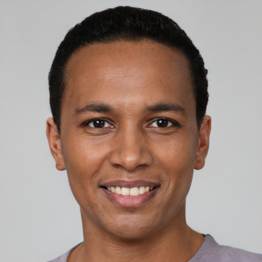 Joyful black young-adult male with short  black hair and brown eyes