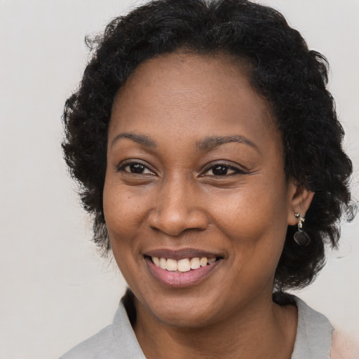 Joyful black adult female with long  brown hair and brown eyes