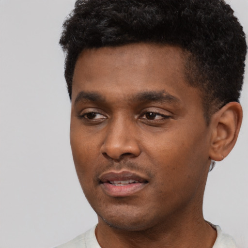 Joyful black young-adult male with short  black hair and brown eyes