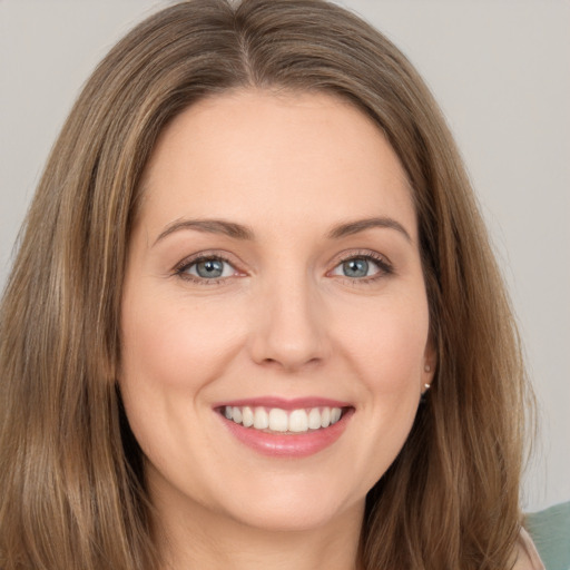 Joyful white young-adult female with long  brown hair and green eyes