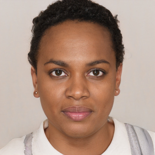 Joyful black young-adult female with short  black hair and brown eyes