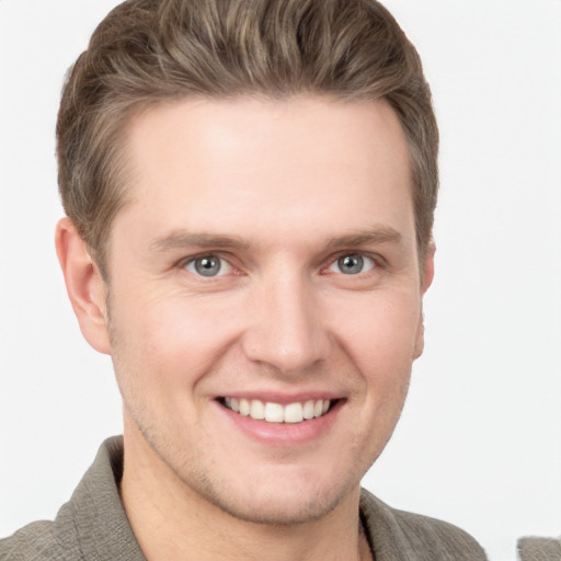 Joyful white young-adult male with short  brown hair and grey eyes