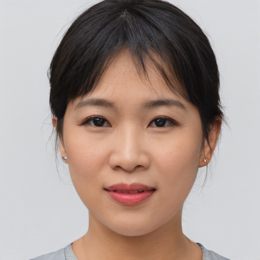 Joyful asian young-adult female with medium  brown hair and brown eyes