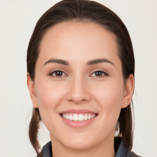 Joyful white young-adult female with long  brown hair and brown eyes