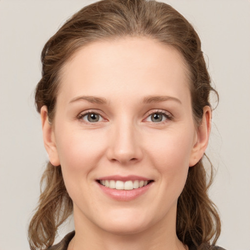 Joyful white young-adult female with medium  brown hair and green eyes