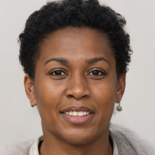 Joyful black young-adult female with short  brown hair and brown eyes