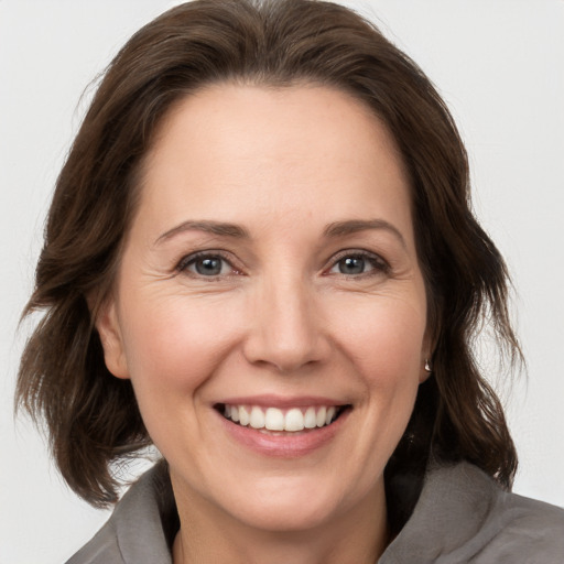 Joyful white adult female with medium  brown hair and brown eyes