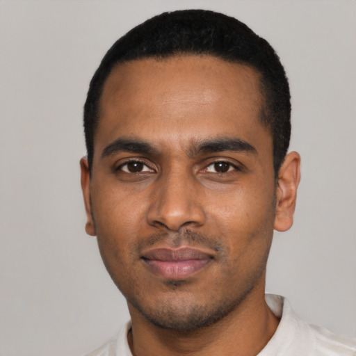 Joyful black young-adult male with short  black hair and brown eyes