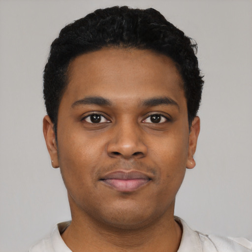 Joyful black young-adult male with short  black hair and brown eyes