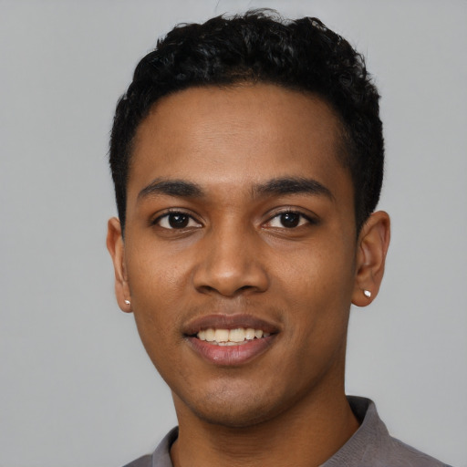 Joyful black young-adult male with short  black hair and brown eyes