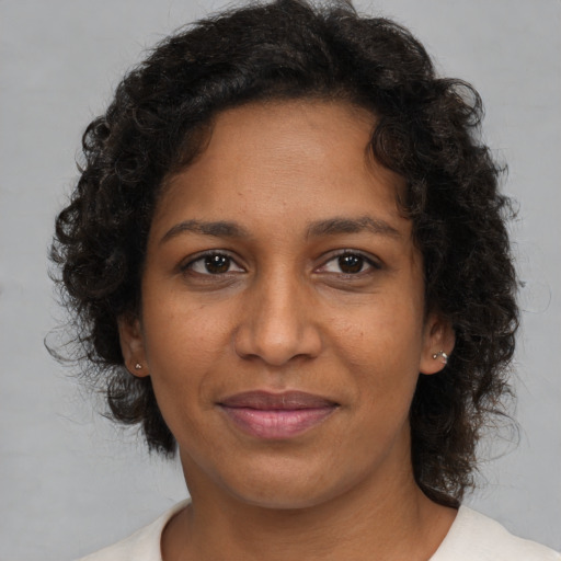 Joyful black adult female with medium  brown hair and brown eyes