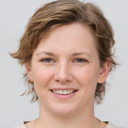 Joyful white young-adult female with medium  brown hair and grey eyes