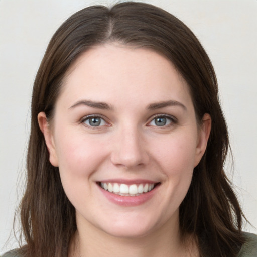 Joyful white young-adult female with long  brown hair and grey eyes