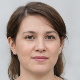 Joyful white young-adult female with medium  brown hair and grey eyes