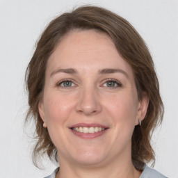 Joyful white adult female with medium  brown hair and grey eyes