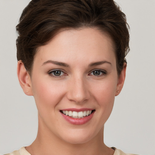 Joyful white young-adult female with short  brown hair and grey eyes