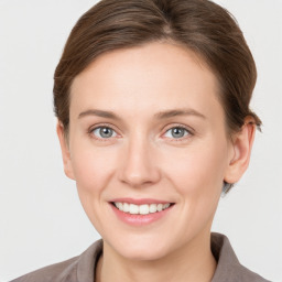 Joyful white young-adult female with medium  brown hair and grey eyes