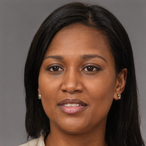 Joyful black young-adult female with long  brown hair and brown eyes
