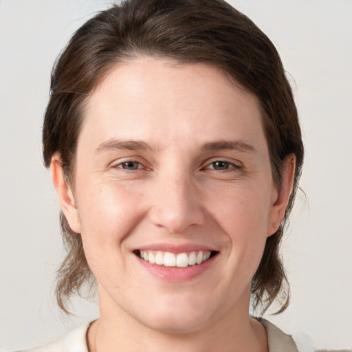 Joyful white young-adult female with medium  brown hair and grey eyes