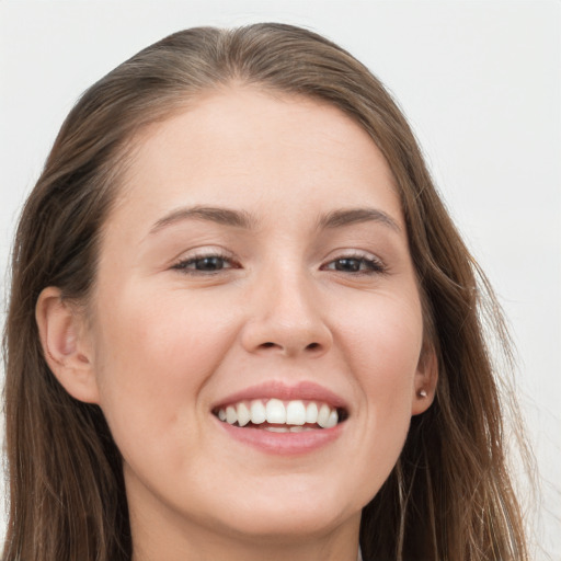 Joyful white young-adult female with long  brown hair and grey eyes