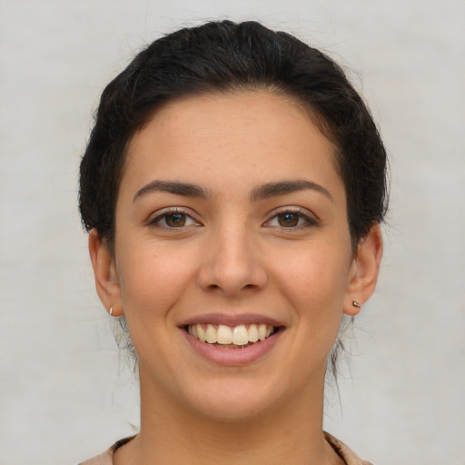 Joyful latino young-adult female with short  brown hair and brown eyes