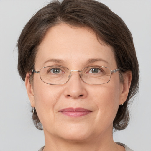 Joyful white adult female with medium  brown hair and grey eyes