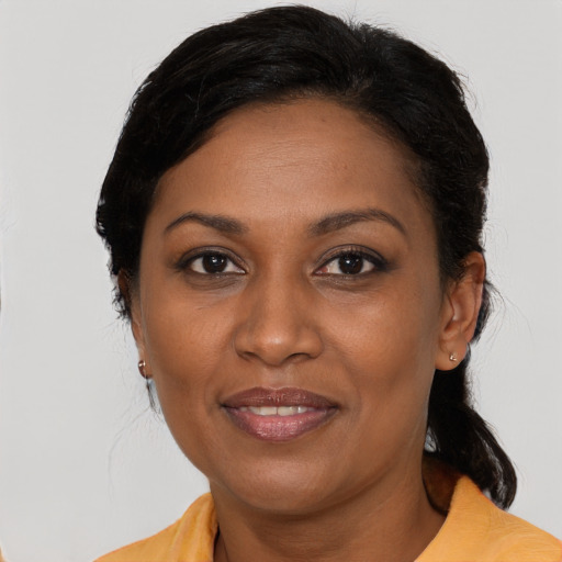 Joyful black adult female with medium  brown hair and brown eyes