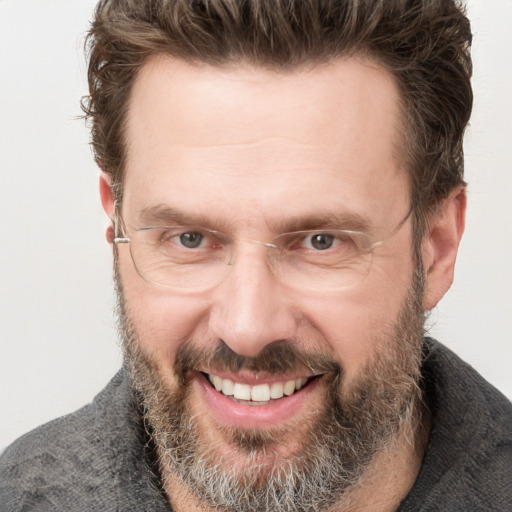 Joyful white adult male with short  brown hair and grey eyes