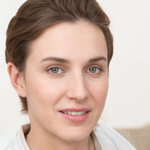 Joyful white young-adult female with short  brown hair and grey eyes