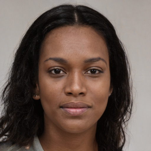 Joyful black young-adult female with long  black hair and brown eyes