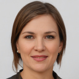 Joyful white young-adult female with medium  brown hair and grey eyes