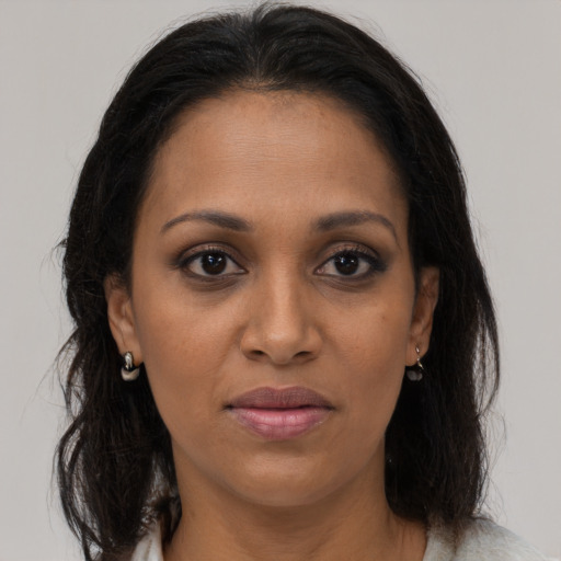 Joyful black young-adult female with long  brown hair and brown eyes