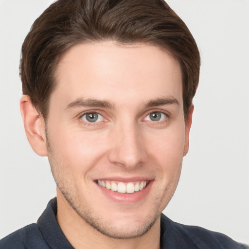 Joyful white young-adult male with short  brown hair and grey eyes