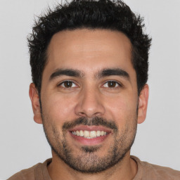 Joyful white young-adult male with short  black hair and brown eyes