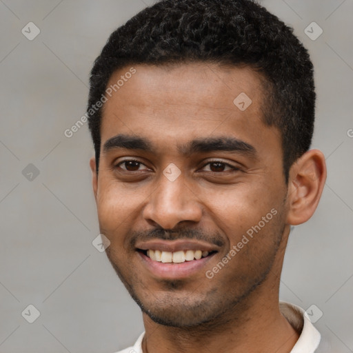 Joyful black young-adult male with short  black hair and brown eyes