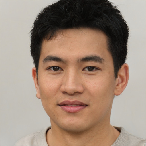 Joyful asian young-adult male with short  black hair and brown eyes