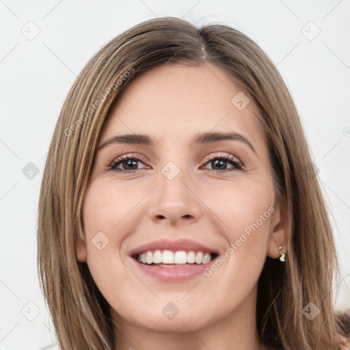 Joyful white young-adult female with long  brown hair and green eyes