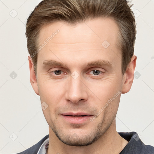 Joyful white young-adult male with short  brown hair and grey eyes