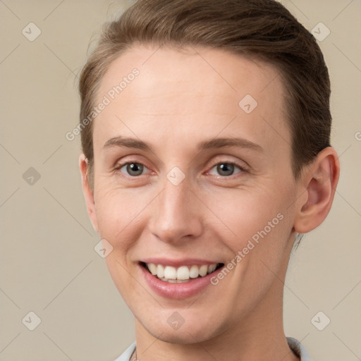 Joyful white young-adult female with short  brown hair and grey eyes