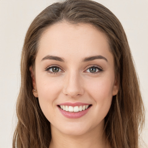 Joyful white young-adult female with long  brown hair and grey eyes