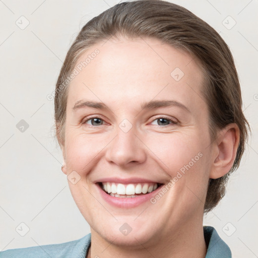 Joyful white young-adult female with medium  brown hair and grey eyes