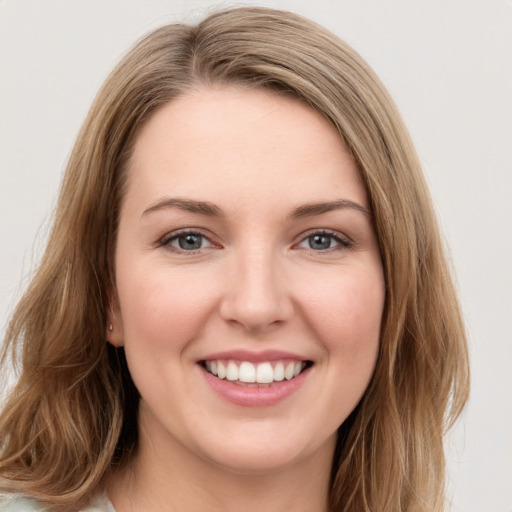 Joyful white young-adult female with long  brown hair and green eyes