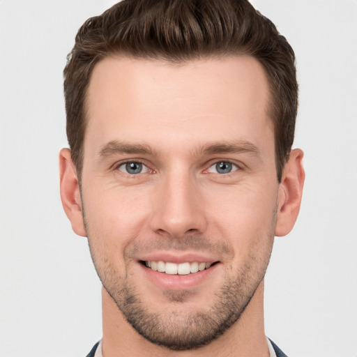 Joyful white young-adult male with short  brown hair and grey eyes