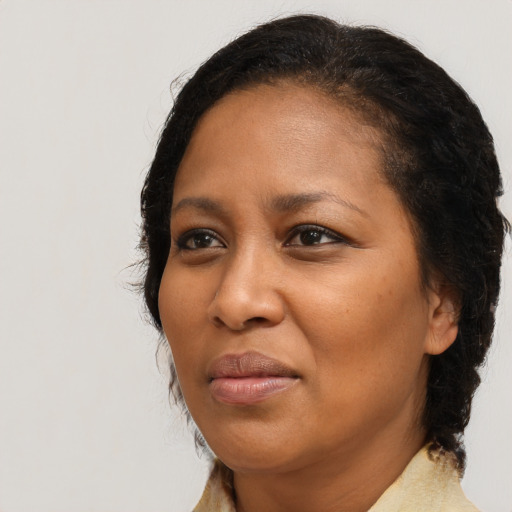 Joyful black adult female with medium  brown hair and brown eyes